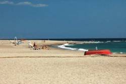 Playa de Carboneras barca roja sobre la arena
